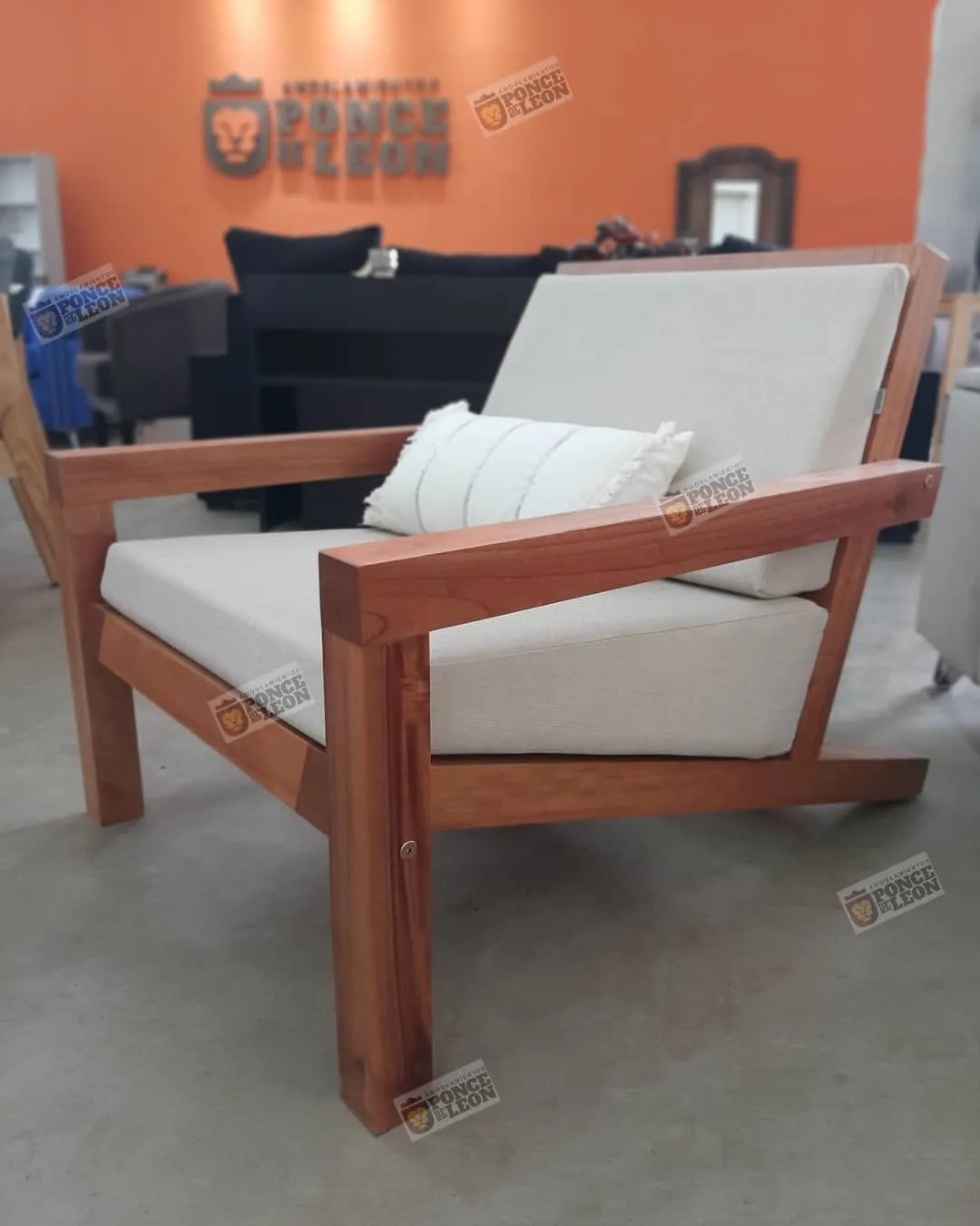 Sillón de madera con almohadones en Amoblamientos Ponce de León